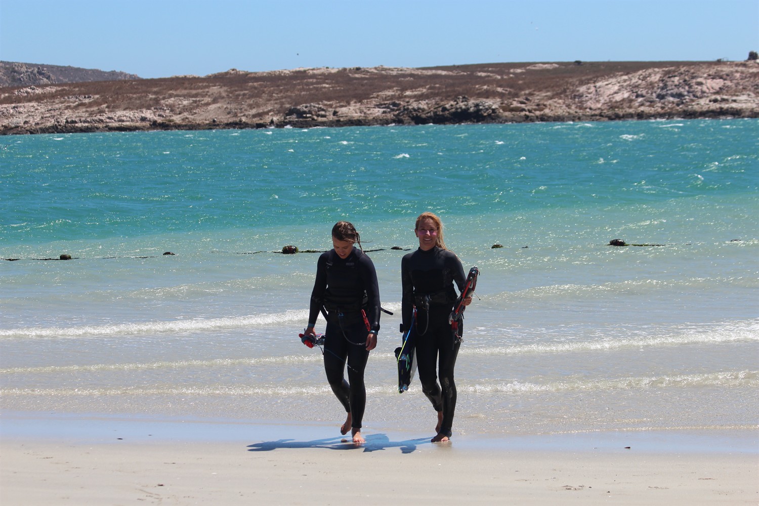 Deux riders sortant de l'eau, planches sous le bras