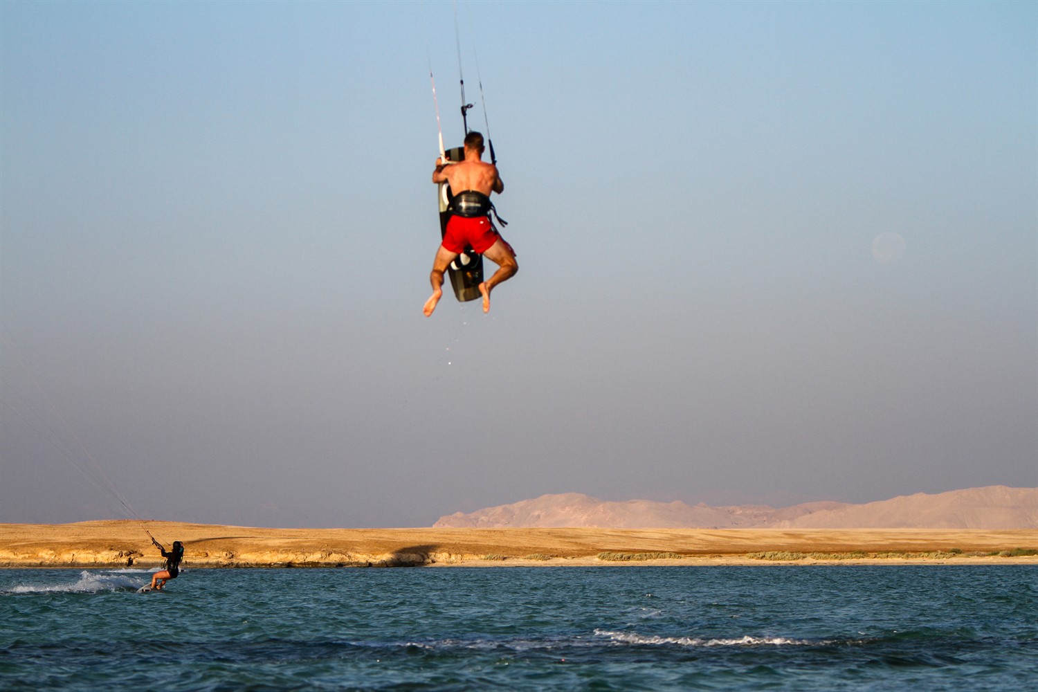Rider en plein saut au-dessus d'un lagon désertique