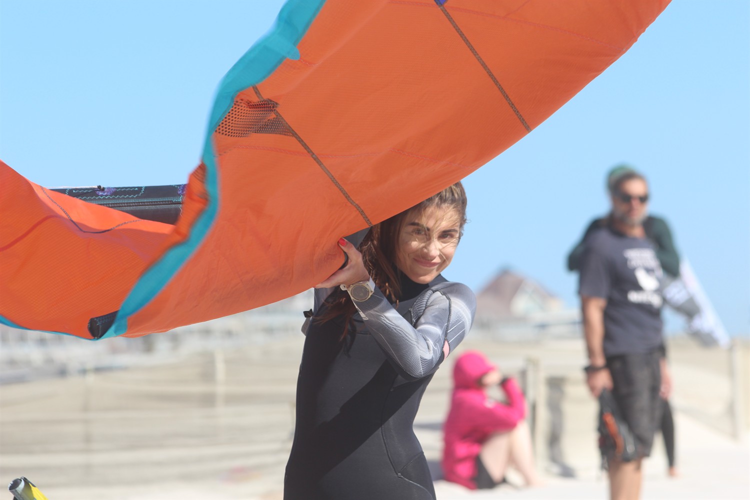 Rider souriante portant son kite orange